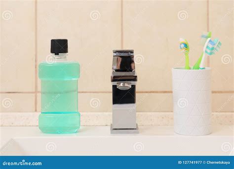 Mouthwash And Holder With Toothbrushes On Sink In Bathroom Stock Image