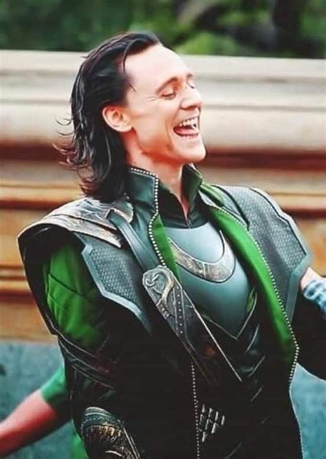 a man dressed as loki in front of a building with his hands out to the side