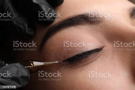 Young Woman Undergoing Procedure Of Permanent Eye Makeup In Tattoo