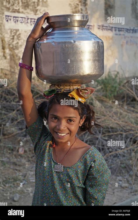 Niña cargando una jarra de agua sobre su cabeza en Rajastán India