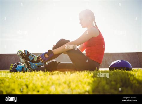 Smiling Sporty Blonde Skater Sitting In Grass Stock Photo Alamy