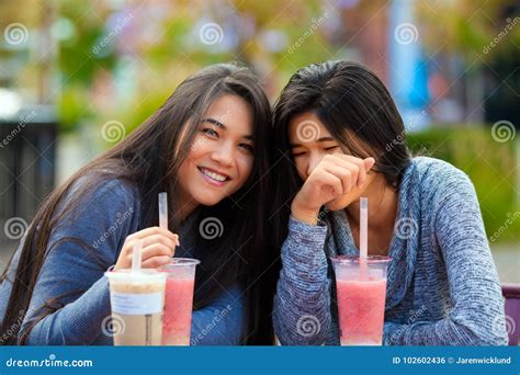 Two Teen Girls At Outdoor Cafe Drinking Boba Tea Together Stock Photo