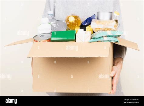 Woman Hands Holding Cardbox With Grocery Products Volunteer Collecting