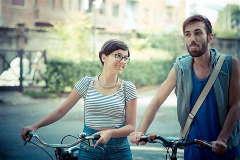 Premium Photo Couple Of Friends Young Man And Woman Riding Bike