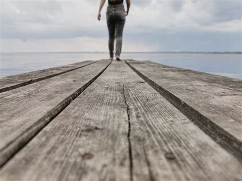 Teenage Girl Walks Across The Bridge Into The Distance Stock Photo