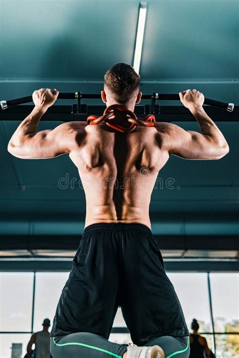 Muscular Man With A Naked Torso Pulls Himself Up On The Horizontal Bar