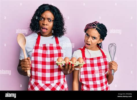 Beautiful African American Mother And Daughter Cooking Cake Using Baker Whisk In Shock Face