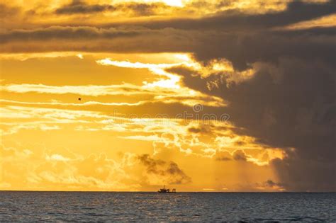 Landscape Of Bright Yellow Sunset Sky Over The Dark Sea Industrial Boat Sails In The Distance