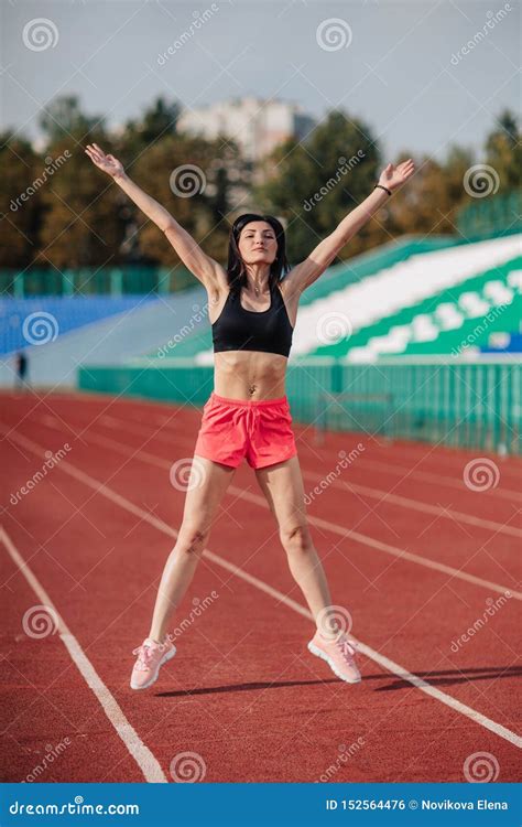 Attractive Sporty Brunette Woman In Pink Shorts And Top Doing Workout