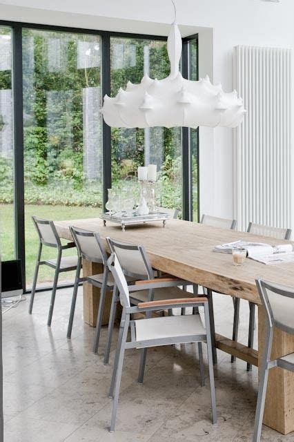 A Dining Room Table And Chairs In Front Of Large Windows