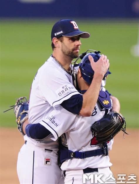 Two Baseball Players Hugging Each Other On The Field