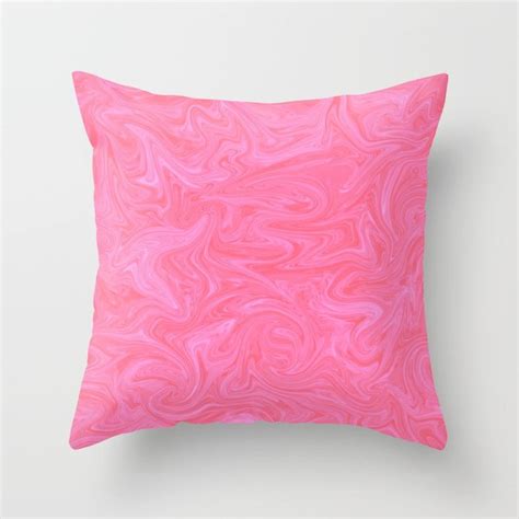 A Pink Pillow On A White Wall With An Abstract Design In The Middle And