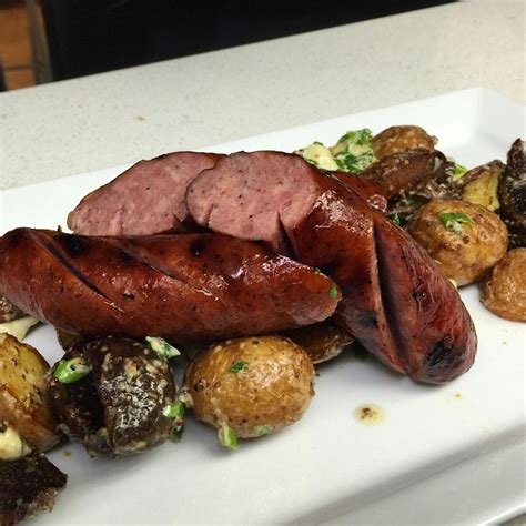 A White Plate Topped With Meat And Potatoes