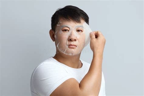 Asian Man Face Mask Portrait Of Guy Removing Sheet Mask From Healthy