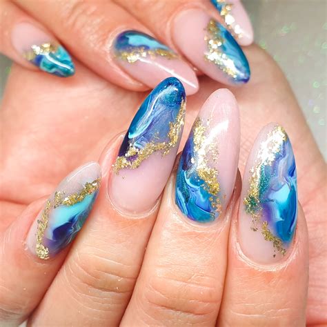 Long Pinky Nude Nails With A Marble Type Ocean Wave Looking Design