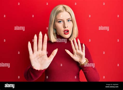 Jeune femme blonde portant des vêtements décontractés se déplaçant les mains paumes montrant le