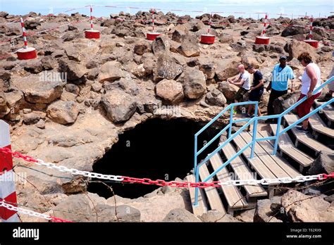 Tourists Looking Down Into The Natural Phenomena Known As The Blue Eye