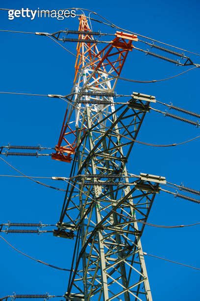 High Voltage Tower With Electricity Transmission Power Lines Against