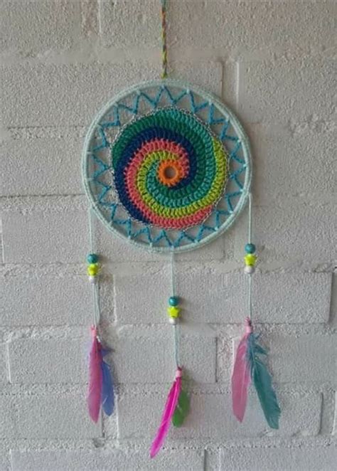 A Crocheted Dream Catcher Hanging On A Brick Wall With Colorful Beads