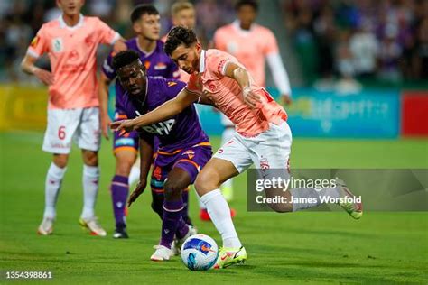 Josh Cavallo of Adelaide United fends off Pacifique Niyongabire of ...