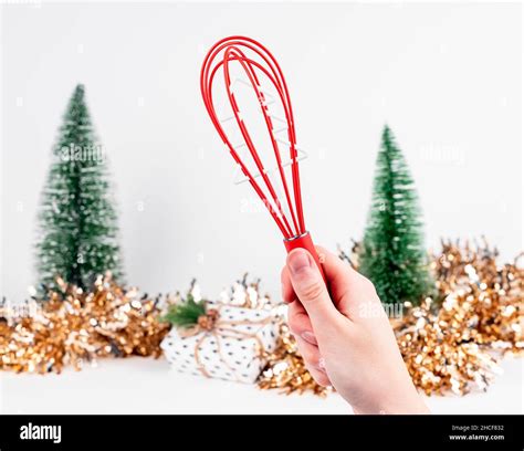 Red Whisk Tool In Hand And Christmas And New Year Decor Stock Photo Alamy