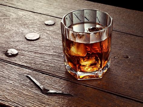 A Glass Filled With Ice Sitting On Top Of A Wooden Table