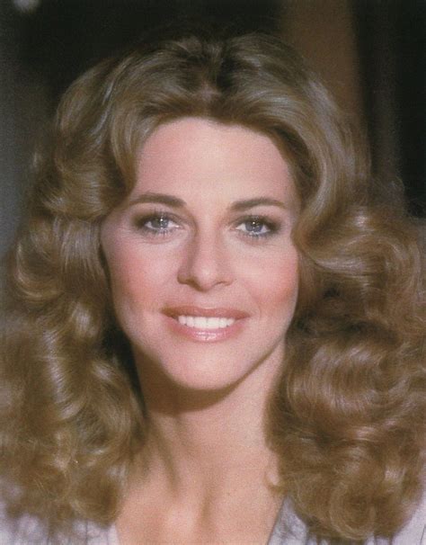 A Close Up Of A Woman With Blonde Hair And Blue Eyes Smiling At The Camera