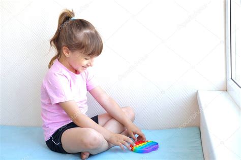 Una Chica Con Una Camiseta Rosa Juega Con Un Juguete De Moda Pop It