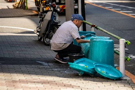 Tokio Japón 1 de noviembre de 2023 Hombre lavando contenedores en un