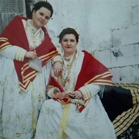 Two Women Dressed In White And Red Sitting Next To Each Other