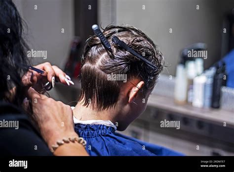 Female Barbeshoper Cuts The Back Of The Hair With A Comb For A Teenage
