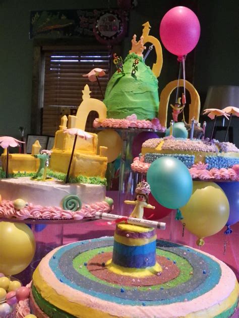 A Table Topped With Lots Of Cakes And Balloons