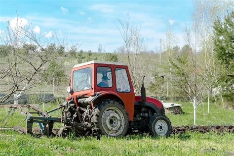 Máquinas de trator modernas que aram o campo agrícola na fazenda na