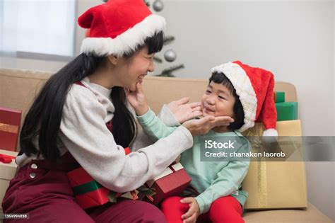 귀여운 아시아 가족 어머니와 아들이 선물 상자를 주고 서로 크리스마스 이브 축제에서 엄마와 작은 아이 드레싱 크리스마스 테마