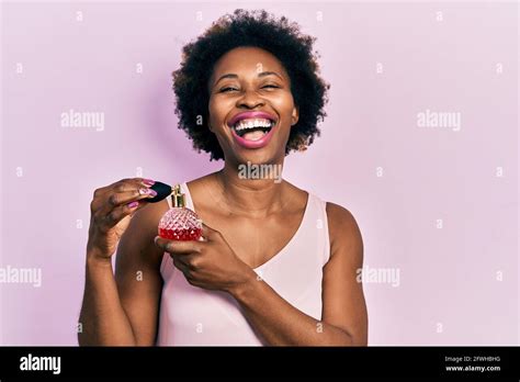 Young African American Woman Holding Perfume Smiling And Laughing Hard