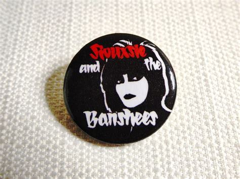 A Black Button With The Words Punk And An Image Of A Woman S Face