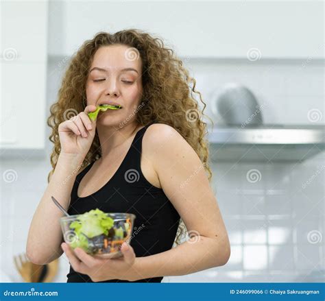 Inspiration Of Smart Caucasian Woman Eating Vegetable Salad In Kitchen