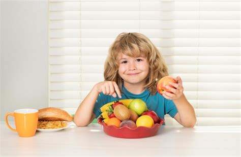 Kind isst apfel gesunde ernährung für kinder süßer junge genießt das