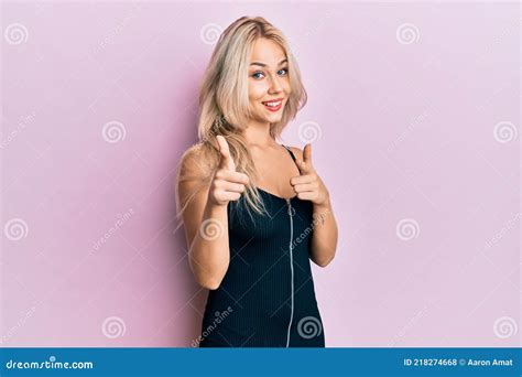 Beautiful Caucasian Blonde Girl Wearing Party Dress Pointing Fingers To