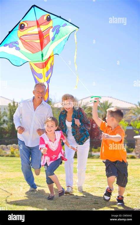 Family flying a kite in a park Stock Photo - Alamy