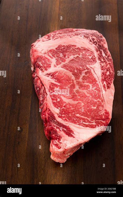 A Raw New York Strip Ribeye Steak Thick Steak On A Cutting Board Stock