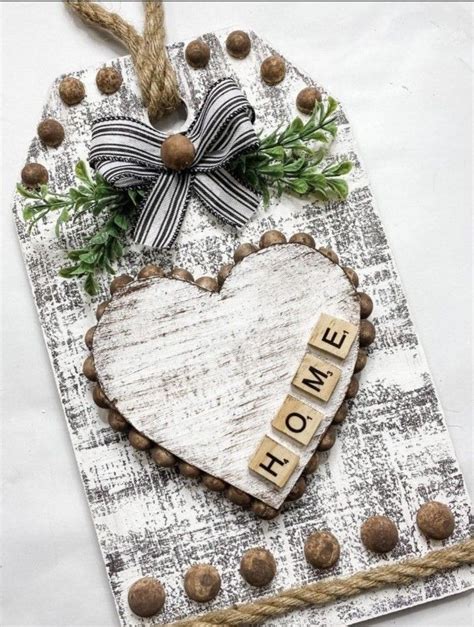 A Heart Shaped Plaque With The Word Home Spelled On It And Tied To A Rope