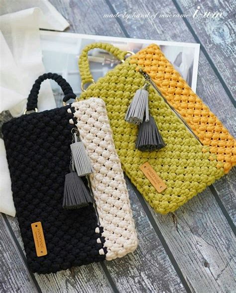 Two Crocheted Purses Sitting On Top Of A Wooden Table Next To Each Other