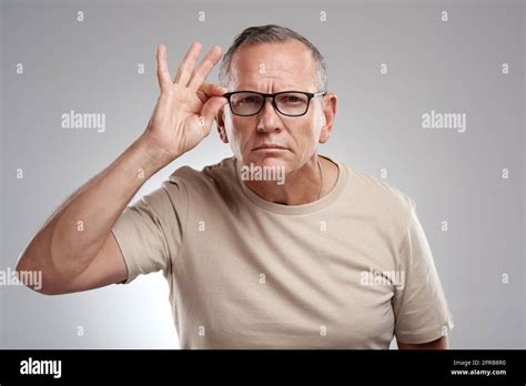 Hang On A Minute A Handsome Mature Man Standing Alone Against A Grey