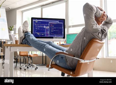Mature Male Programmer Sitting In Light Office At His Workplace Stock