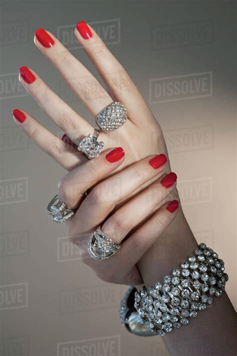 Close Up Of Woman S Hands With Red Nail Polish And Diamond Jewelry