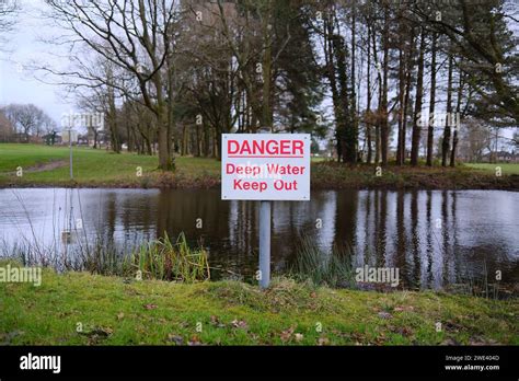 Danger Deep Water Warning Sign By A Water Filled Pond Risk To The