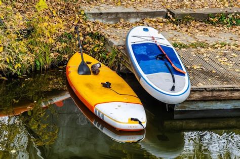 Un kayak amarillo y naranja está al lado de un bote pequeño Foto Premium