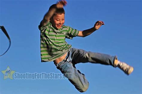 Boy Jumping From Swing At Playground