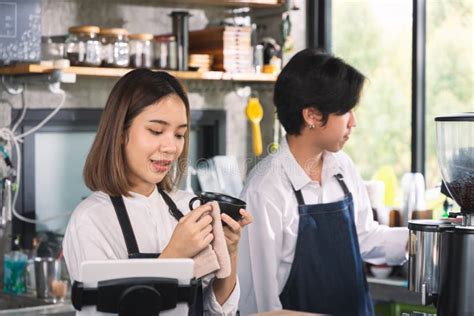 Two Asian Coffee Waitress Making Cup Of Hot Coffee Latte In Coffee Shop